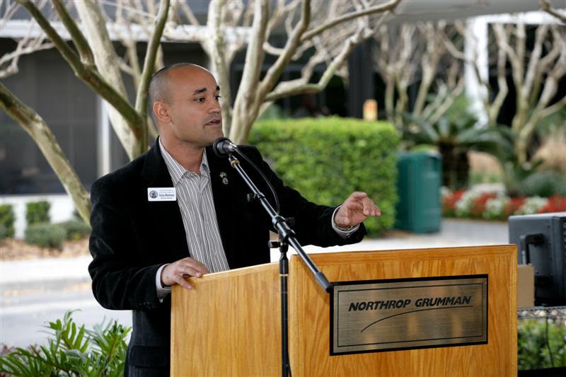 Julius Melendez speaking at a business event podium